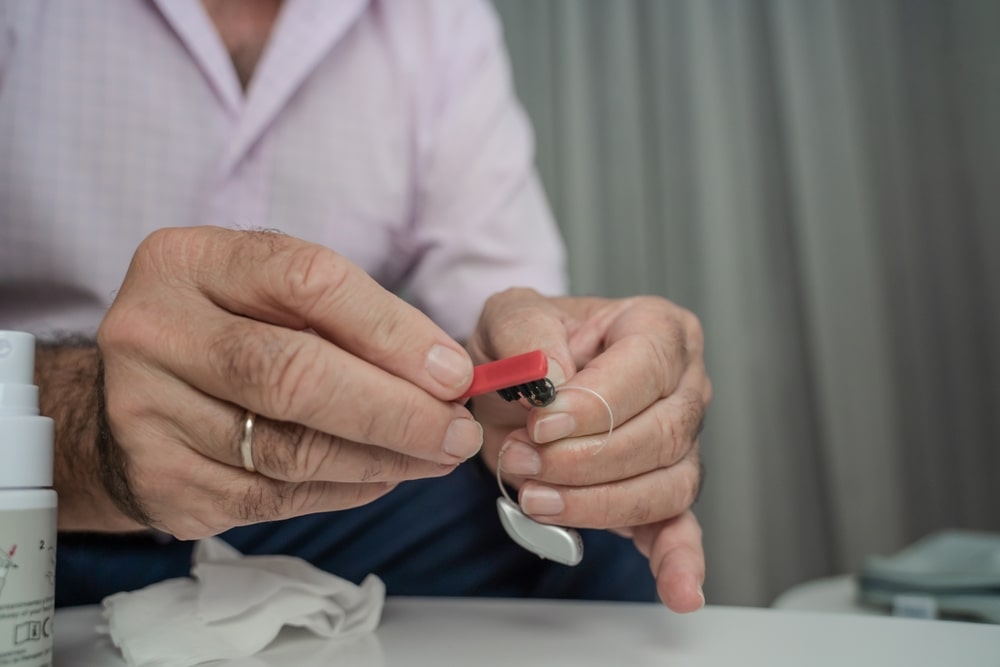 Person cleaning their hearing aids.